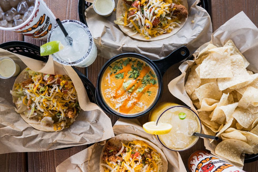A spread of tacos, queso and beverages at Torchy's Tacos.