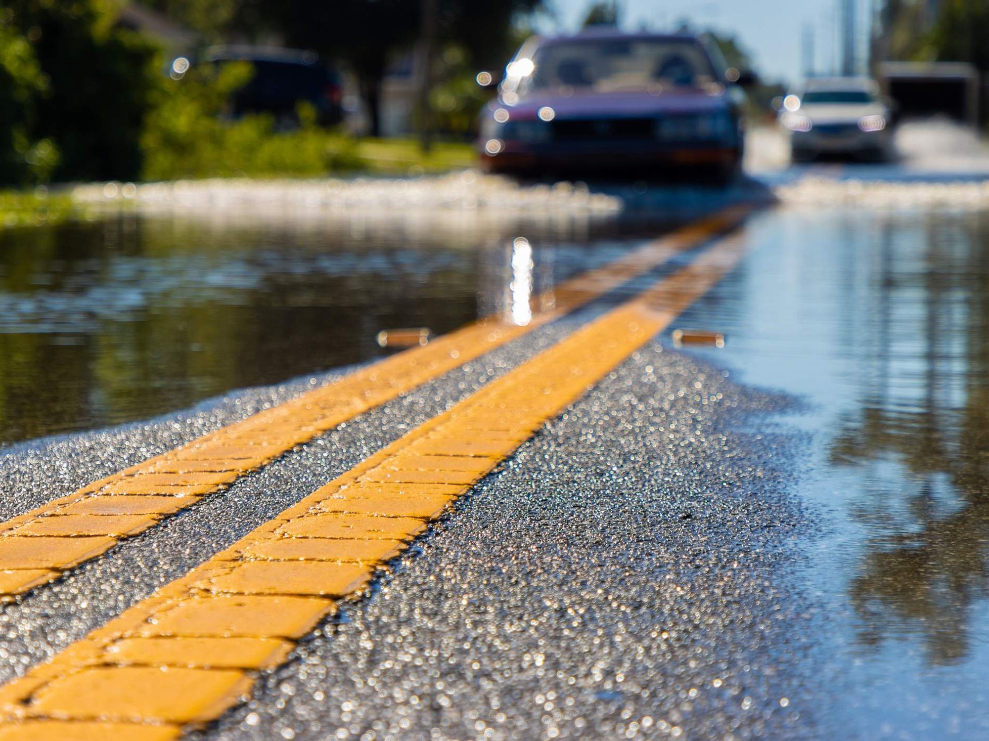Car driving through flooded road after storm