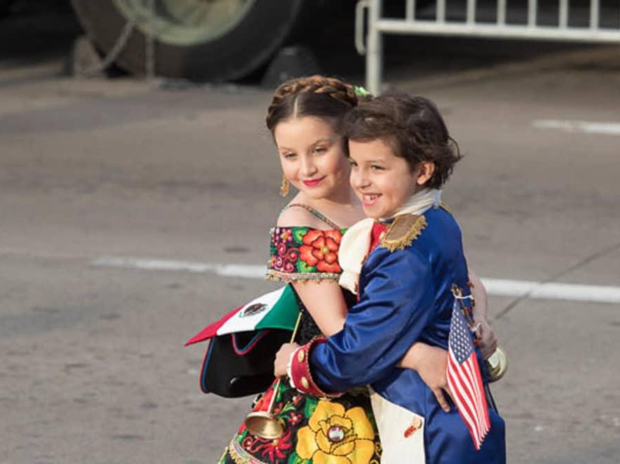 Children from Laredo and Nuevo Laredo in historical costumes exchange abrazos.