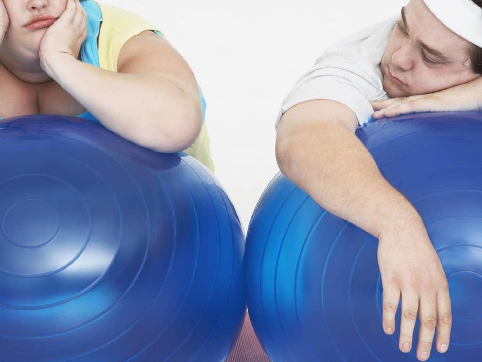 fat couple trying to exercise with balls