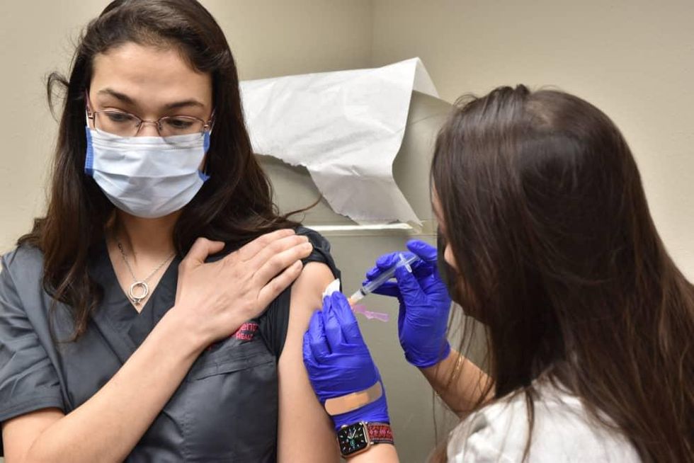 H-E-B woman getting covid-19 vaccine shot healthcare worker