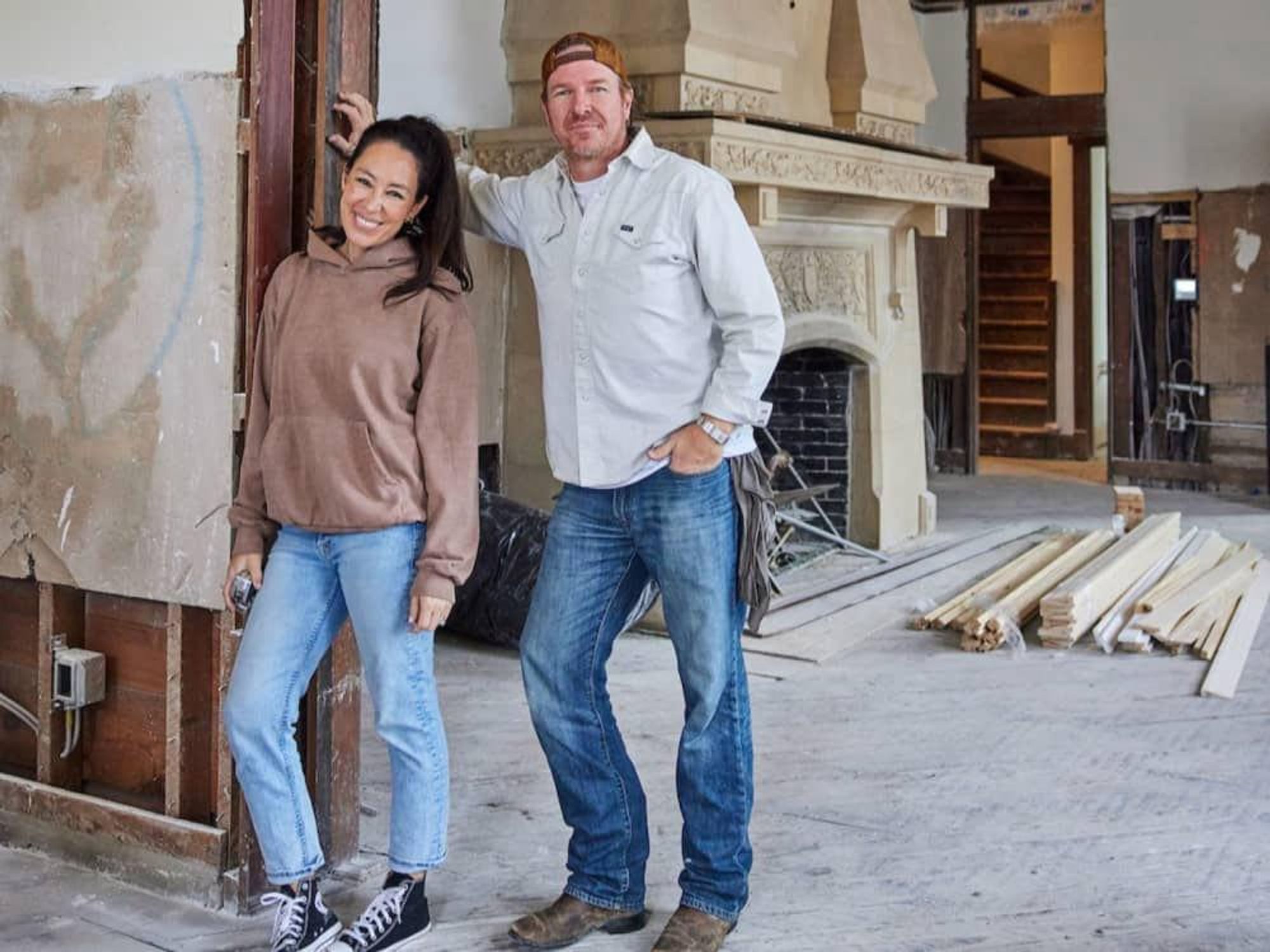 Jo and Chip in front of a Caen stone fireplace in the Cottonland Castle.