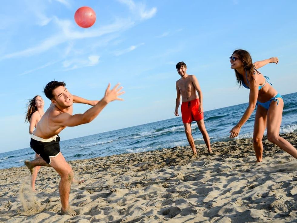 People playing ball on the beach