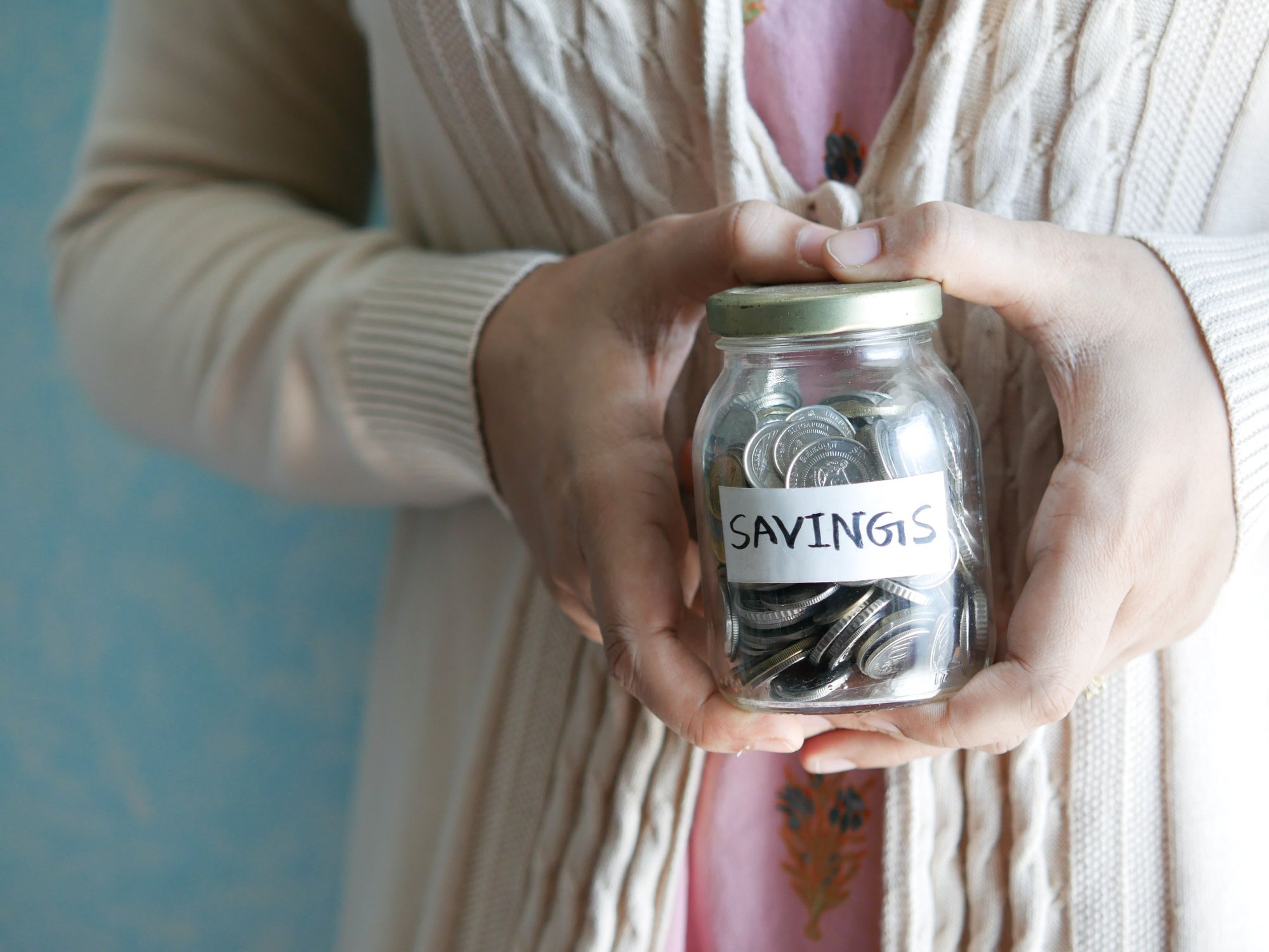 Person holding a "savings" jar