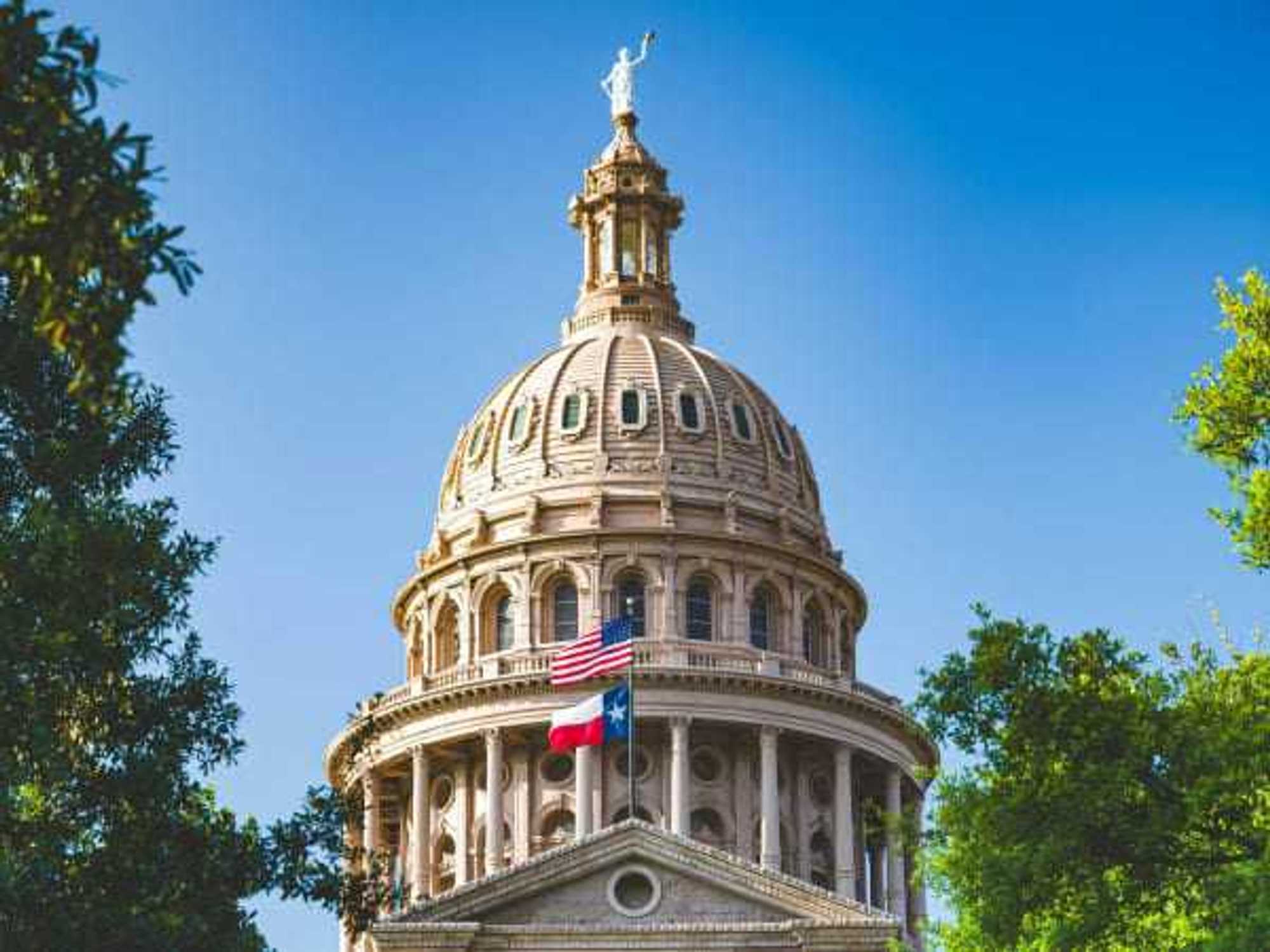 Texas Capitol building with state and US flags