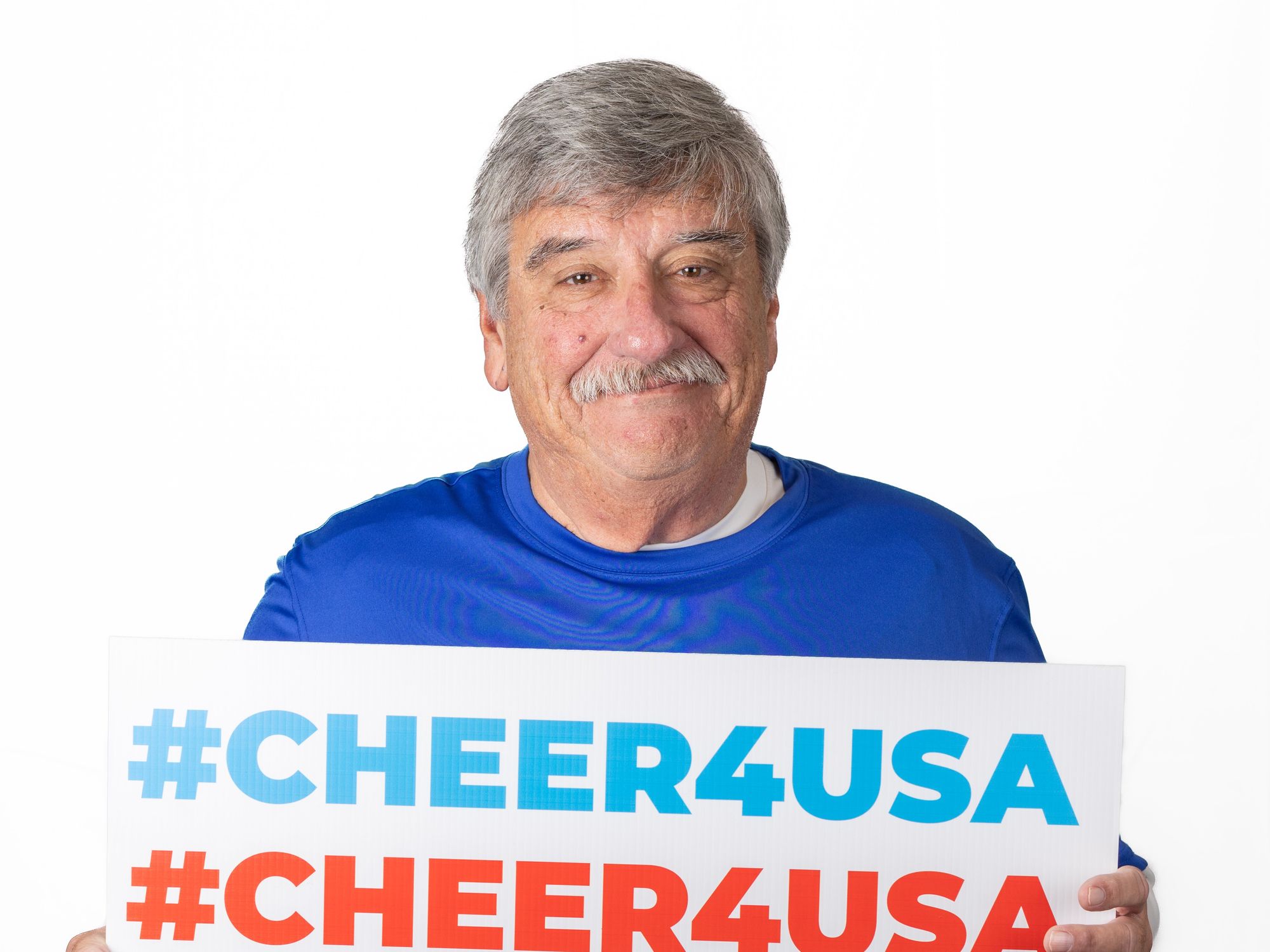 The Head Coach of the Texas Special Olympics Sailing team holding a #CHEER4USA sign