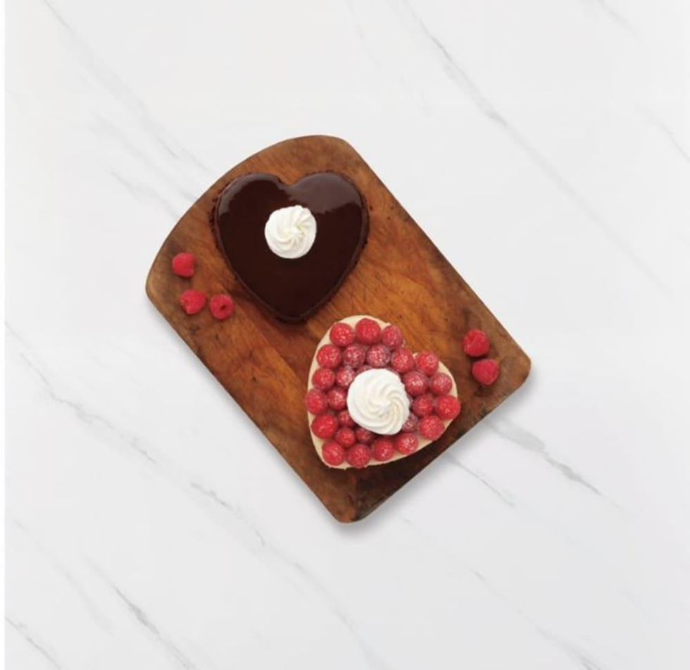 Two heart-shaped cheesecakes against a white marble background.
