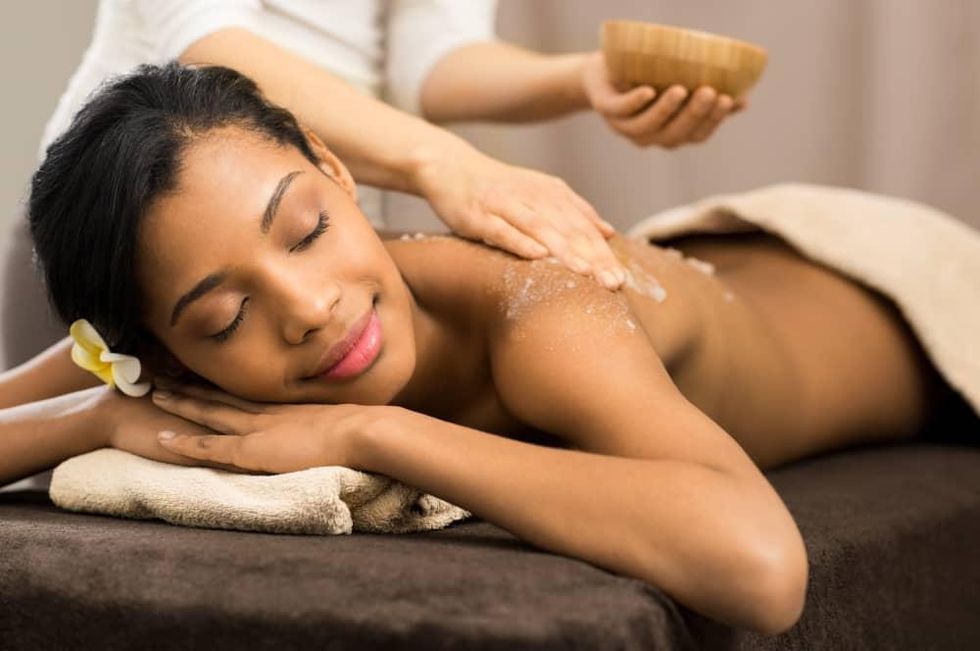 Woman receiving a passion fruit agave body scrub